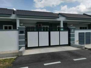a house with a black and white gate at M Guest House in Muar