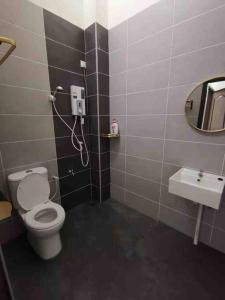 La salle de bains est pourvue de toilettes et d'un lavabo. dans l'établissement M Guest House, à Muar