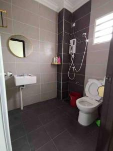 La salle de bains est pourvue de toilettes, d'un lavabo et d'un miroir. dans l'établissement M Guest House, à Muar