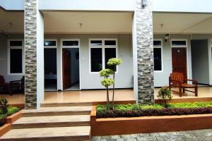 a front porch of a house with stairs and a bench at RedDoorz Syariah near Alun Alun Purwokerto 2 in Purwokerto
