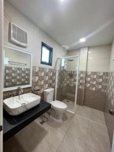 a bathroom with a toilet and a shower and a sink at 243Hotel in Ta Phraya
