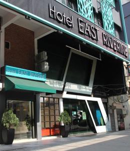 a hotel entrance with two potted plants in front of it at East Riverine Boutique Hotel in Kuala Lumpur