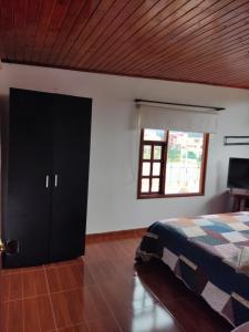 1 dormitorio con cama y ventana en Hermoso Altillo en casa de familia, en Chía