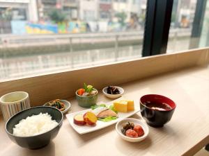 uma mesa com pratos de comida e tigelas de arroz em Joytel Hotel Namba Dotonbori em Osaka