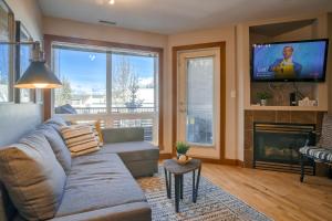 a living room with a couch and a tv at Incredible Mountain View Townhouse in DT Canmore w/ A/C & U/A Parking in Canmore