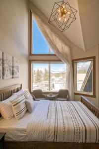 a bedroom with a large bed with a large window at Incredible Mountain View Townhouse in DT Canmore w/ A/C & U/A Parking in Canmore