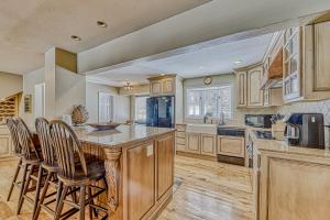 a kitchen with wooden cabinets and a island with bar stools at Legacy Villa in Brian Head