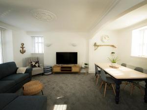 a living room with a table and a tv at Sandpiper Cottage in Buckie