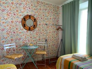 リスボンにあるGuestHouse Penaのテーブル、椅子2脚、鏡が備わる客室です。
