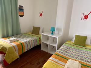 Cette chambre comprend 2 lits et une armoire blanche. dans l'établissement GuestHouse Pena, à Lisbonne