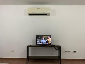 a television on a table with a air conditioner at CASA ROMEL in Ciudad Valles