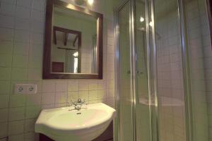 een badkamer met een wastafel en een glazen douche bij Hostal Miramar in Deia