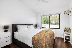 a bedroom with a large bed and a window at Banksia Villa in Eganstown