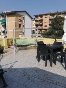 un patio con mesa, sillas y un columpio en Appartamento Stefania, en La Spezia