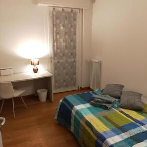 a bedroom with a bed and a desk and a table and chair at B&B Markone Bologna Center in Bologna