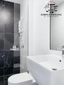 a bathroom with a sink and a toilet and a mirror at Beacon Executive Suites in George Town