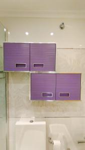 a bathroom with two purple cabinets above a sink at Apartamento con piscina y WIFI a 100 metros de la playa en Somo in Somo