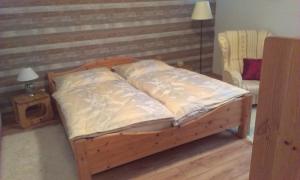 una cama de madera con almohadas y una silla en una habitación en Herberts Stubn en Feldkirchen bei Graz