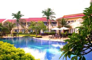 a large swimming pool in front of a resort at The Hans Coco Palms in Puri