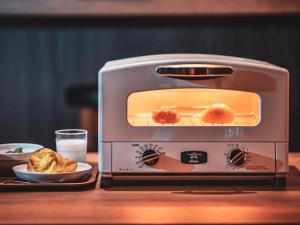 a toaster oven sitting on a table with food in it at Henn na Hotel Tokyo Ginza in Tokyo