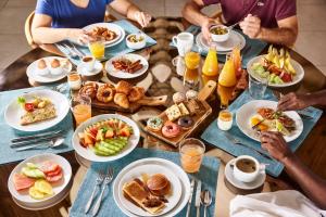 a group of people sitting around a table eating breakfast at C Mauritius in Belle Mare