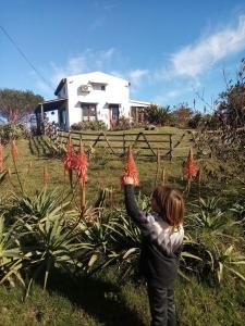 Ein junges Mädchen, das vor einem Haus einen Drachen fliegt. in der Unterkunft El Rancho de arenas de Jose Ignacio in José Ignacio