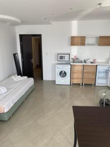 Habitación con cama y cocina con microondas. en Safo Apartments and Rooms, en Sozopol