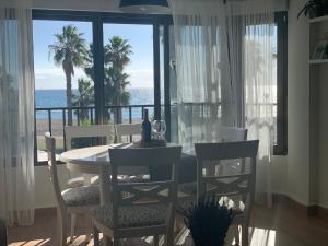 Apartamento Puerto Blanco في كاليتا دي فيليز: غرفة طعام مع طاولة وكراسي والمحيط
