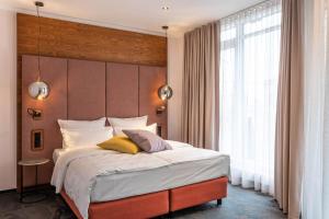 um quarto com uma cama grande e uma janela grande em Hotel Neuer Fritz em Berlim