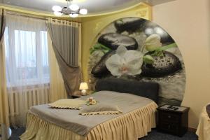 1 dormitorio con 1 cama con una pintura en la pared en Natali Luxury Apartments, en Voronezh
