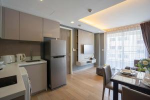 cocina y comedor con nevera y mesa en Dazzle Residence, en Bangkok