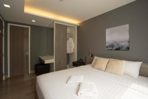 Un dormitorio con una cama grande con sábanas blancas. en Dazzle Residence, en Bangkok