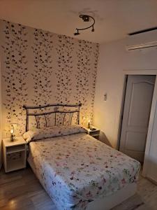 a bedroom with a bed with flowers on the wall at Atico Duplex Marques de Reyes in Seville