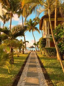 a pathway leading to a house with palm trees at Constance Sakoa Boutik in Trou aux Biches