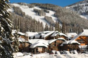 a ski lodge with snow covered roofs on a mountain at Kandahar Lodge at Whitefish Mountain Resort in Whitefish
