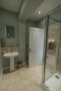 a bathroom with a shower and a sink and a glass door at Breedon Hall in Derby