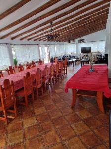 a dining room with red tables and chairs and a television at Casa BonDia in Paraul Rece