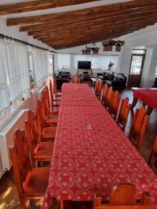 Casa BonDia في باراول ريسيه: طاولة طويلة وكراسي في غرفة مع قماش الطاولة الحمراء