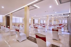 HOTEL CENTRAL PARK & CONFERENCE CENTRE في نيروبي: غرفة كبيرة مع كراسي وطاولات بيضاء