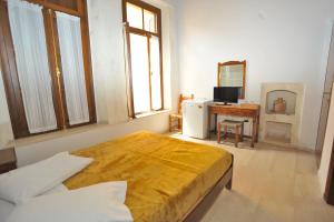 a bedroom with a bed and a television and a desk at Hotel Byzantine in Rethymno