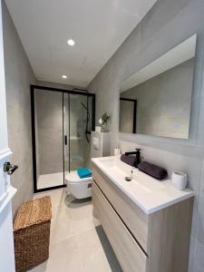 a bathroom with a sink and a toilet and a mirror at amazing new property in the heart of the old town of antibes in Antibes