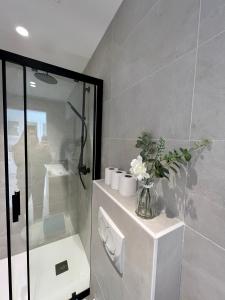 a bathroom with a shower and a vase of flowers at amazing new property in the heart of the old town of antibes in Antibes