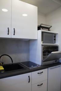 eine Küche mit einer Spüle und einer Mikrowelle in der Unterkunft Apartament Wrocław Borowska in Breslau