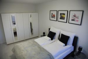 a living room with a white couch with pillows at Apartament Wrocław Borowska in Wrocław