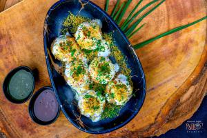 a plate of food with meatballs and herbs on a table at Hotel Namo Residency in Vijayawāda