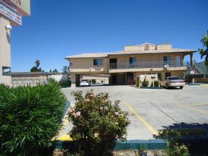 a building with a car parked in a parking lot at Economy Inn in Victorville