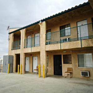 a building with tables and chairs in front of it at Economy Inn in Victorville