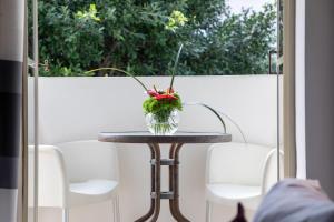 une table avec un vase de fleurs sur elle dans l'établissement Cinema Hotel - an Atlas Boutique Hotel, à Tel Aviv