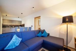 ein Wohnzimmer mit einem blauen Sofa und einer Küche in der Unterkunft Camping Passeier Garten in Saltaus