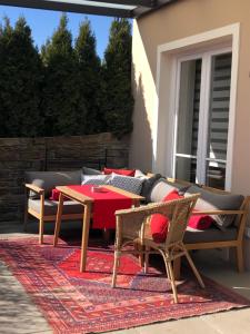 um pátio com uma mesa e cadeiras num tapete em Villa zur Schmied'n em Ehrenhausen
